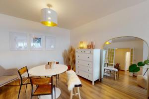ein Wohnzimmer mit einem Tisch und einem Spiegel in der Unterkunft Le Bucolique - appart 1 chambre in Annecy