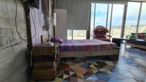 een slaapkamer met een bed in een kamer met ramen bij Studio Dbayeh Near Abc Wz Duplex Rooftop, Sea View in Dbayeh
