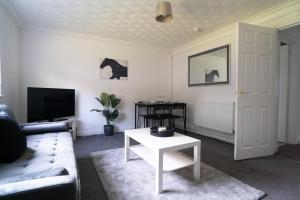 un soggiorno con un divano e un tavolo di Deedes Apartment ad Airdrie