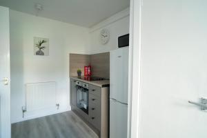 a small kitchen with a refrigerator and a stove at Deedes Apartment in Airdrie