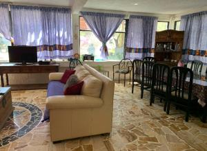 ein Wohnzimmer mit einem Sofa, einem Tisch und Stühlen in der Unterkunft Finca MacNoy Casa 12 personas Ixmiquilpan,Hgo cerca balnearios y Tolantongo in Ixmiquilpan