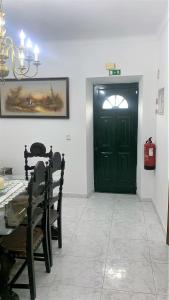 een kamer met een zwarte deur en een tafel en stoelen bij Casa da Avó Pipa in Reguengos de Monsaraz