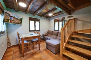 sala de estar con mesa y sofá en Bonito Apartamento Rural, Wifi, terraza y piscina en Navelgas, en Tineo