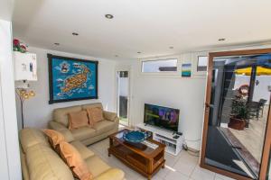 een woonkamer met een bank en een tv bij Villa Alegranza - LH190 By Villas Now Ltd in Playa Blanca