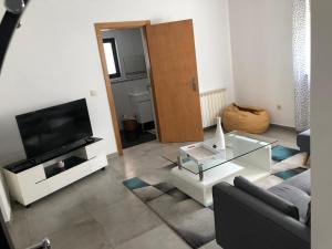 a living room with a couch and a tv and a table at Moradia Activ Mar\Vão in Vila Real
