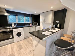 a kitchen with a washer and dryer at Comfy Apartments - Finchley Road in London