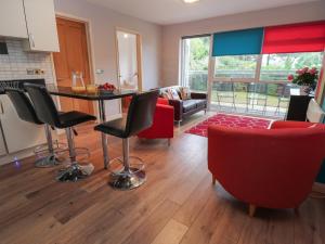 cocina y sala de estar con mesa y sillas en Flat 5 Fairwinds en Poole