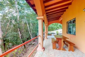 eine Veranda eines Hauses mit einer Holzbank in der Unterkunft Framadani Villas Gold Standard Certified in San Ignacio