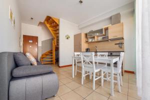 Una sala de estar con un sofá y una mesa y una cocina. en Plaża II, Sun & Snow, en Świnoujście
