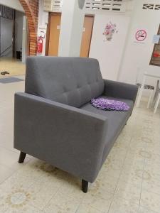a grey couch with a purple pillow on it at Happy Bentong Guest House in Bentong