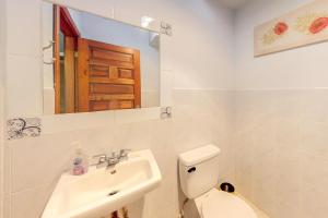 a bathroom with a sink and a toilet and a mirror at Framadani Villas Gold Standard Certified in San Ignacio