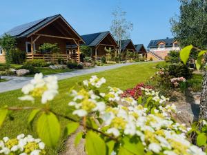 a row of cottages with flowers in a yard at Domek z balią in Chmielno