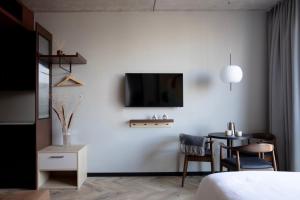 a bedroom with a bed and a table and a tv at Bob W Amsterdam Noord in Amsterdam