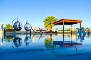 uma piscina de água com um pavilhão e palmeiras em Villa Rose em Kolimbia