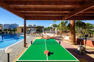 a ping pong table next to a swimming pool at Villa Rose in Kolimbia