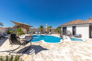 eine Terrasse mit Pool und Stühlen und ein Haus in der Unterkunft Rustic Luxury Villas Dalma & Dalmata in Murvica