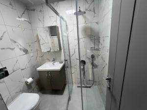 a bathroom with a shower and a toilet and a sink at Elit Otel in Antalya +27 photos