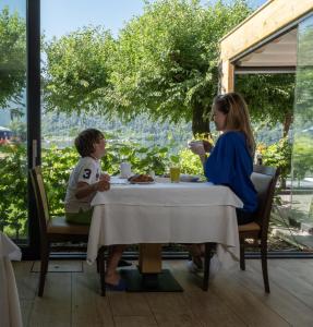 Parc Hotel Du Lac في ليفيكو تيرمي: وجود امرأة وطفل يجلسون على طاولة في المطعم