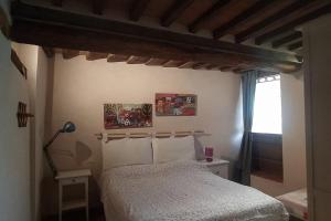 1 dormitorio con cama y techo de madera en Agli Olivi di Marciano, en Siena
