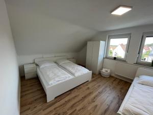 1 dormitorio con 2 camas y 2 ventanas en Premium Apartment 70qm 2 Zimmer Küche, Balkon, Smart TV, WiFi, en Aalen