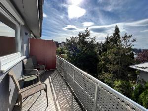 balcón con sillas y vistas a los árboles en Premium Apartment 70qm 2 Zimmer Küche, Balkon, Smart TV, WiFi en Aalen