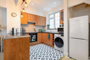uma cozinha com armários de madeira e um frigorífico branco em *-* Beautiful Townhouse in Central London *-* em Londres