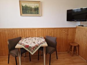 a table with chairs and a table cloth on it at Apartmány Lýdia in Zuberec