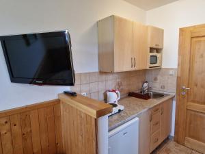 a kitchen with a flat screen tv on the wall at Apartmány Lýdia in Zuberec