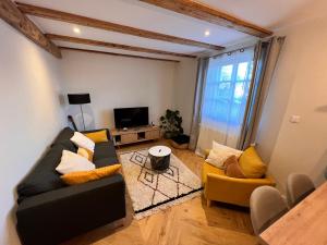 Sala de estar con 2 sofás y TV en Appartement dans un corps de ferme alsacien en Mittelhausbergen