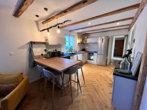 - une cuisine avec une table et des chaises dans la chambre dans l'établissement Appartement dans un corps de ferme alsacien, à Mittelhausbergen