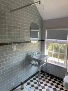 a bathroom with a sink and a tiled wall at Charming country cottage in quiet rural setting 