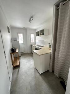eine Küche mit weißen Schränken und einer Arbeitsplatte in der Unterkunft François Mitterrand 2 in Elbeuf