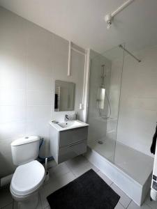 ein weißes Bad mit einem WC und einer Dusche in der Unterkunft François Mitterrand 2 in Elbeuf