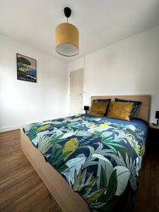 ein Schlafzimmer mit einem großen Bett mit einer bunten Decke in der Unterkunft François Mitterrand 2 in Elbeuf