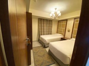 - une chambre d'hôtel avec 2 lits et une porte dans l'établissement Porto El Sokhna Pyramids 2, à Ain Sokhna