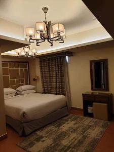 - une chambre avec un grand lit et un lustre dans l'établissement Porto El Sokhna Pyramids 2, à Ain Sokhna