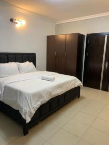 a bedroom with a large bed with a wooden cabinet at Lovely 3 bedroom duplex in Ikeja GRA in Ikeja