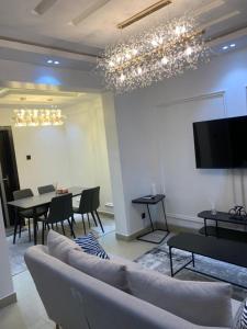 a living room with a couch and a tv and a table at Lovely 3 bedroom duplex in Ikeja GRA in Ikeja