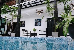 una piscina in una stanza con sedie e ventilatore a soffitto di The Courtyard Chiangrai a Chiang Rai