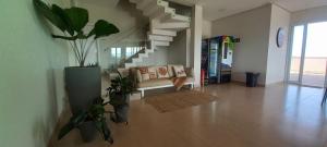 uma sala de estar com um sofá e algumas plantas em Pousada Vila Craton Canastra em São João Batista do Glória