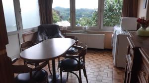 uma cozinha com uma mesa e cadeiras em frente a uma janela em Gite Du bac em Comblain-au-Pont