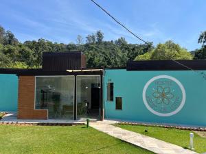 una casa sostenible con fachada azul en Hostel Jardim de Lotus en Blumenau