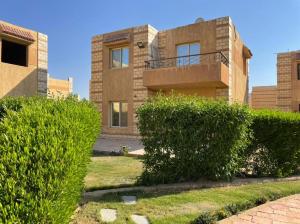 a brick house with bushes in front of it at العين السخنة in Ain Sokhna