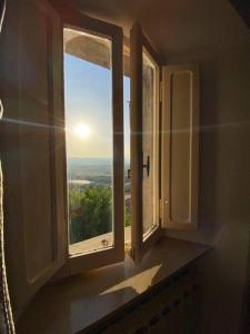 ein Fenster in einem Zimmer mit Blick auf die Sonne in der Unterkunft La casetta di fossato in Fossato di Vico
