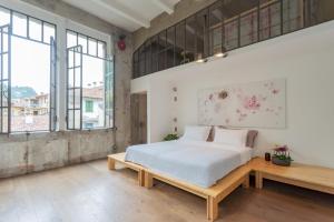 a bedroom with a large bed and a wooden table at Design Loft with Private Parking by Rent All Como in Como