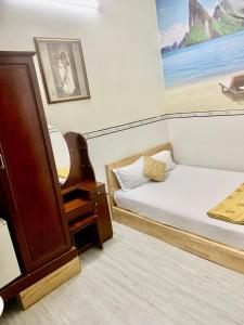 Cette petite chambre comprend un lit et un miroir. dans l'établissement Khánh Vân - VT Cloud mini Hotel, à Vung Tau