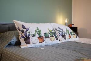 ein Kissen mit einem Haufen Kaktuen auf einem Bett in der Unterkunft La casetta di fossato in Fossato di Vico