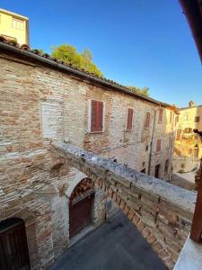 an old brick building with a bridge next to it at La casetta di fossato in Fossato di Vico