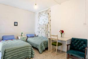 a bedroom with two beds and a desk and a chair at Town House - Private Rooms - Near Sea in Il-Gżira