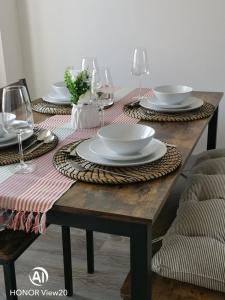 - une table en bois avec des assiettes et des verres à vin dans l'établissement Olive and Carols Walsall Stays, à Walsall